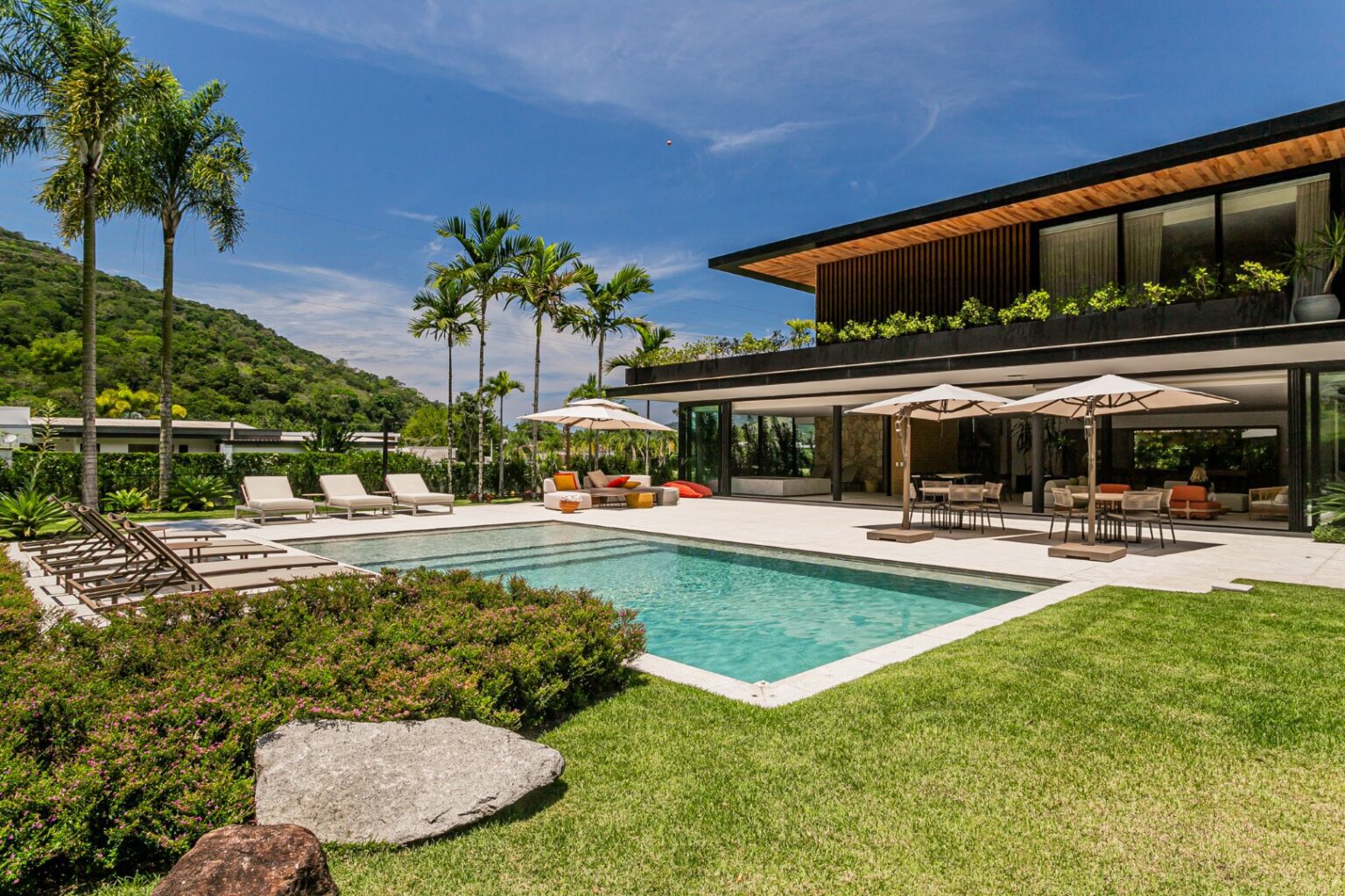 Uma casa que se abre para o lago, na Costa Verde